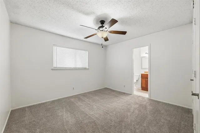 an empty room with closet and ceiling fan
