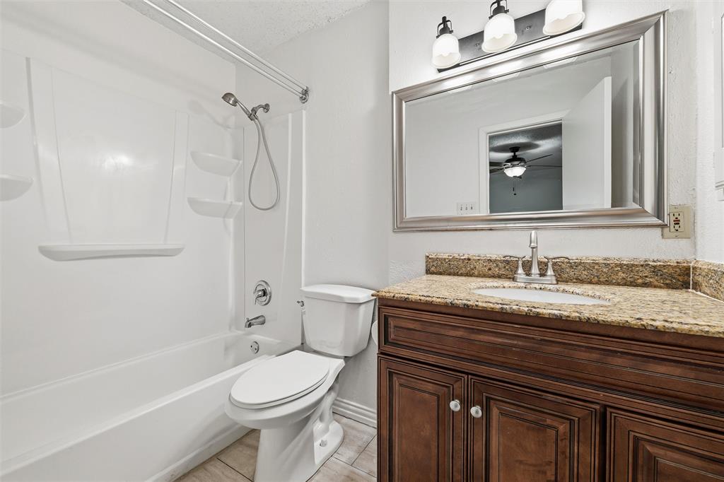 800 Howell Drive Coppell, TX 75019 - Photo 18 of 24 a bathroom with a granite countertop toilet sink and mirror