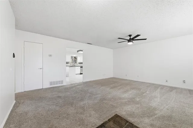 an empty room with windows and ceiling fan