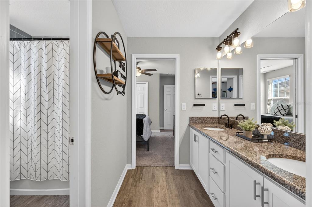 82 Berlin Avenue St. Cloud, FL 34771 - Photo 29 of 44 a spacious bathroom with a granite countertop sink a mirror a vanity and shower