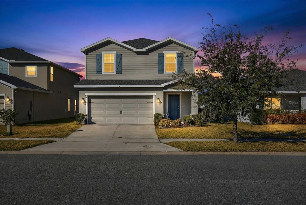 82 Berlin Avenue St. Cloud, FL 34771 - Photo 3 of 44 a front view of a house with a yard and garage