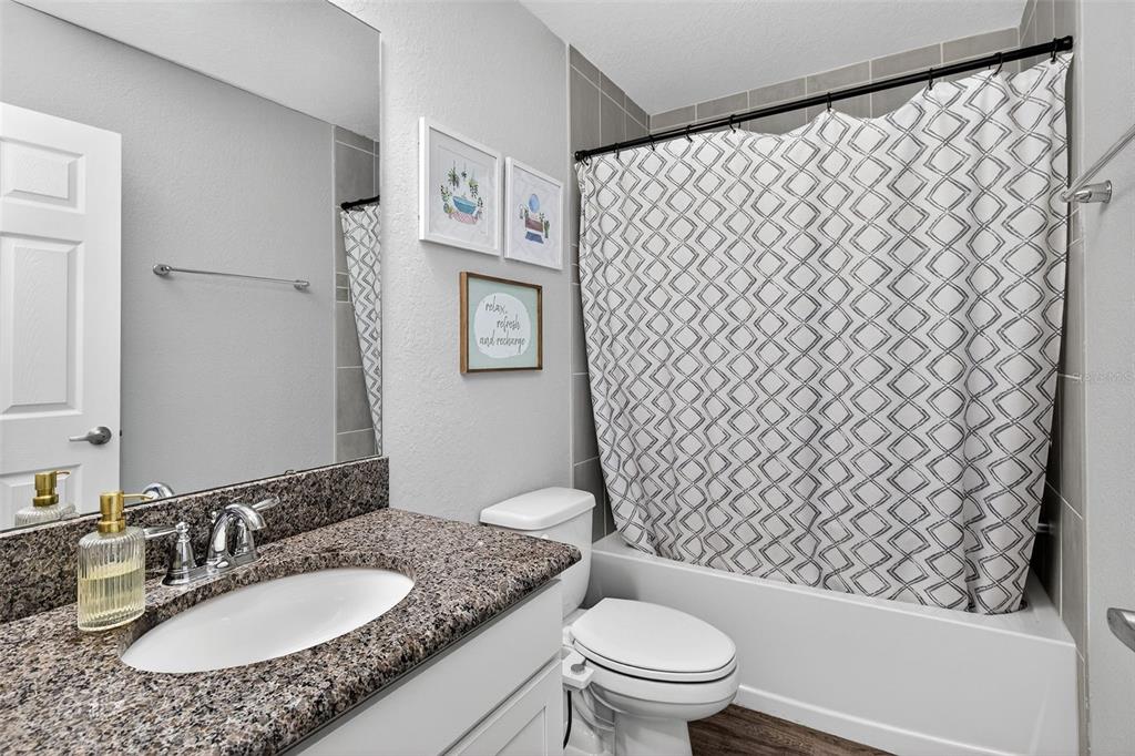 82 Berlin Avenue St. Cloud, FL 34771 - Photo 31 of 44 a bathroom with a granite countertop toilet sink and mirror