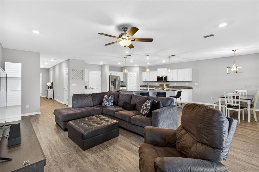 82 Berlin Avenue St. Cloud, FL 34771 - Photo 8 of 44 a living room with furniture kitchen view and a chandelier