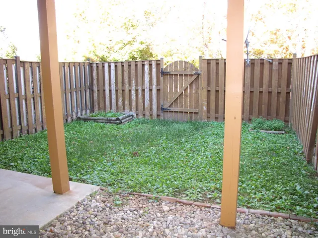 a view of a backyard with wooden fence