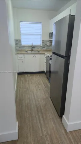 a kitchen with granite countertop a refrigerator and a sink