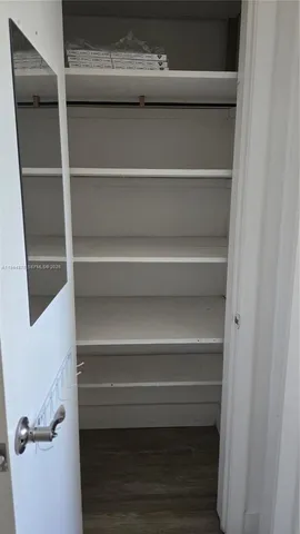 a view of walk in closet with empty racks