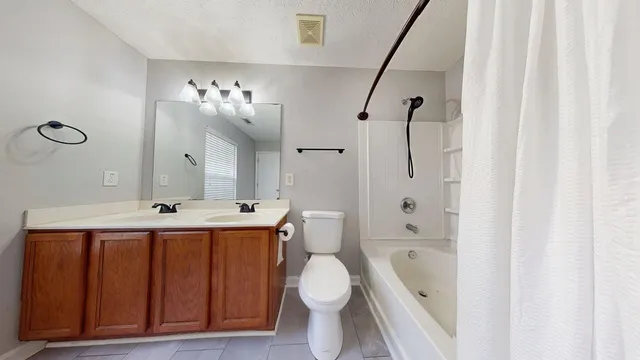 a bathroom with a sink vanity granite toilet and shower
