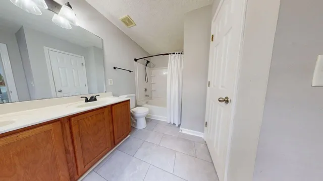 a large bathroom with a tub sink shower and mirror