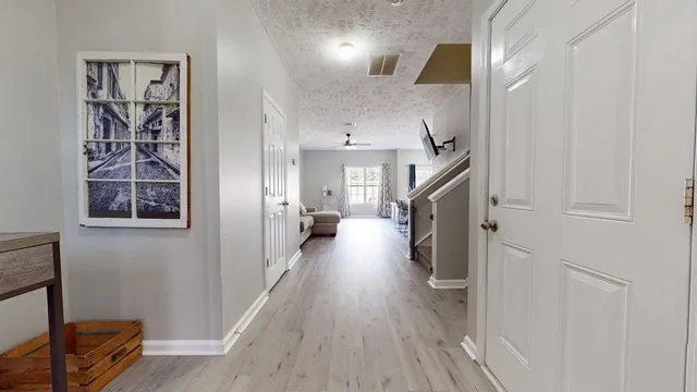 a hallway with wooden floor fireplace and livingroom