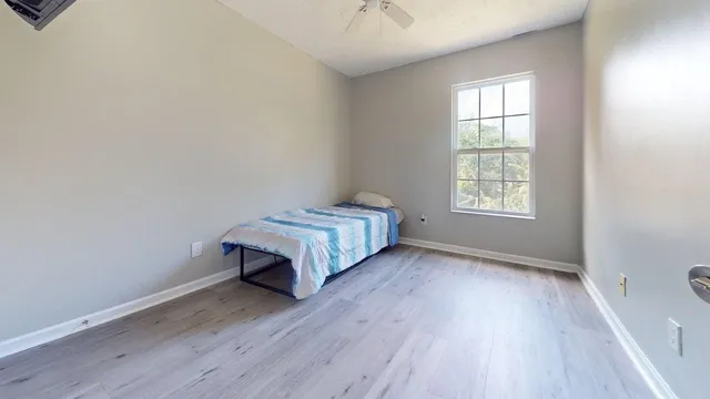 an empty room with a window and wooden floor
