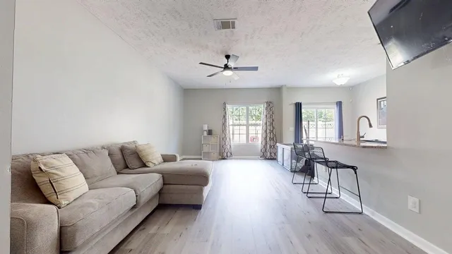 a living room with furniture a ceiling fan and a window
