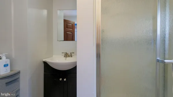 a view of a room that has a window and a chandelier fan