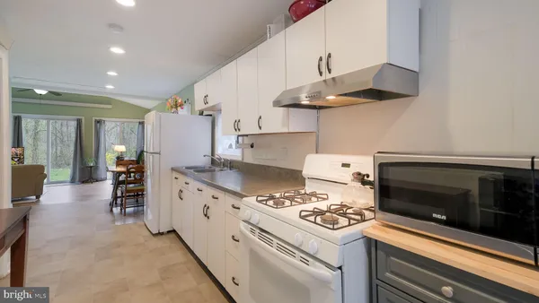 a kitchen with granite countertop sink stainless steel appliances and cabinets