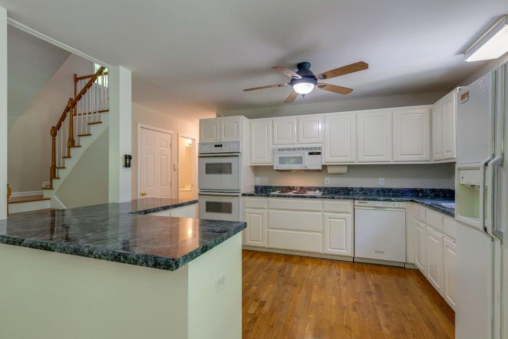 7511 Kingston Road Fairview, TN 37062 - Photo 14 of 42 a kitchen with stainless steel appliances granite countertop a sink a stove and cabinets