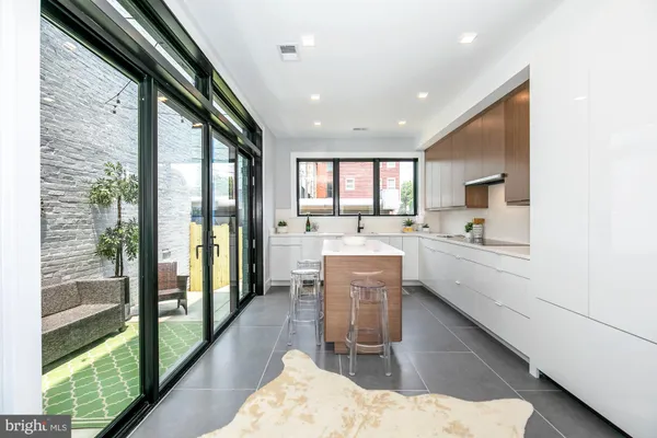 a dining hall with stainless steel appliances kitchen island granite countertop a refrigerator and a sink