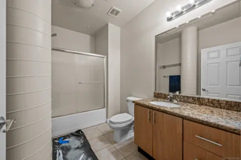 a bathroom with a granite countertop sink toilet and shower