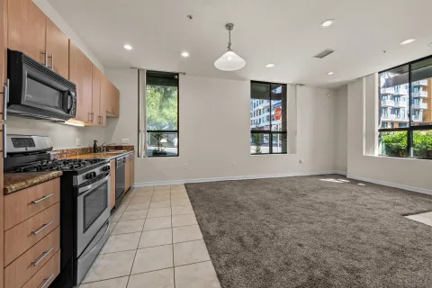 a large kitchen with stainless steel appliances granite countertop a stove a sink and a microwave