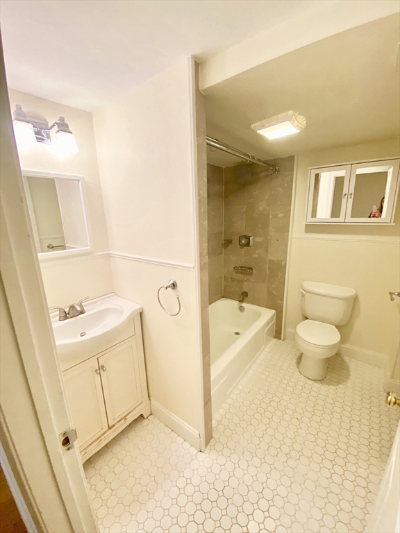 280 Commonwealth Avenue, Unit G8 Boston, MA 02116 - Photo 10 of 12 a bathroom with a granite countertop sink mirror vanity bathtub and toilet
