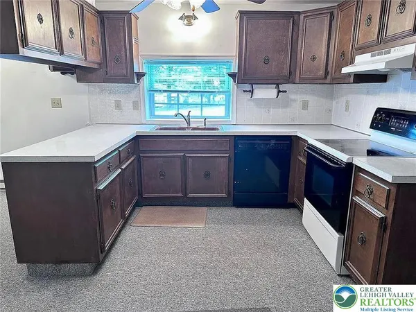 a kitchen with stainless steel appliances granite countertop a sink stove and cabinets