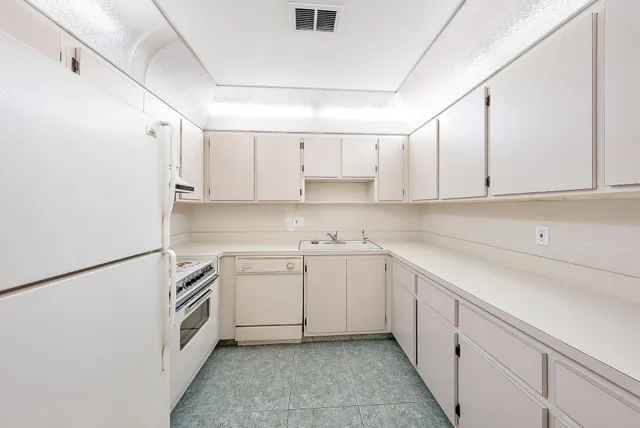 a kitchen with cabinets appliances and a sink
