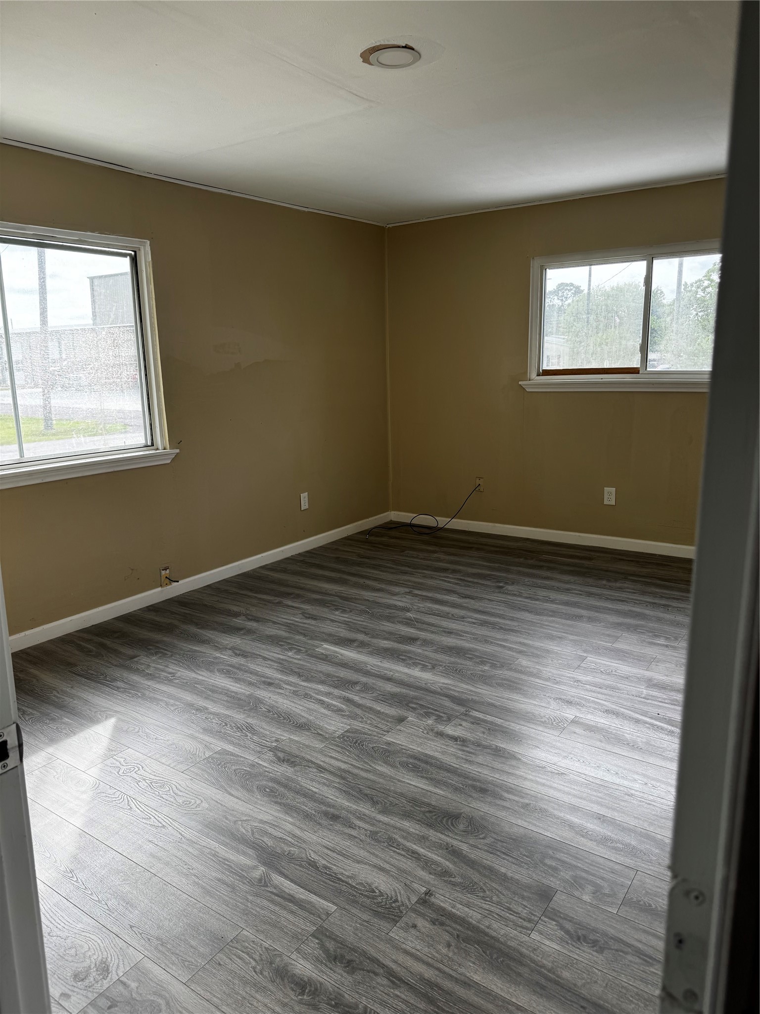 4515 7th Street Bacliff, TX 77518 - Photo 12 of 15 an empty room with wooden floor and windows