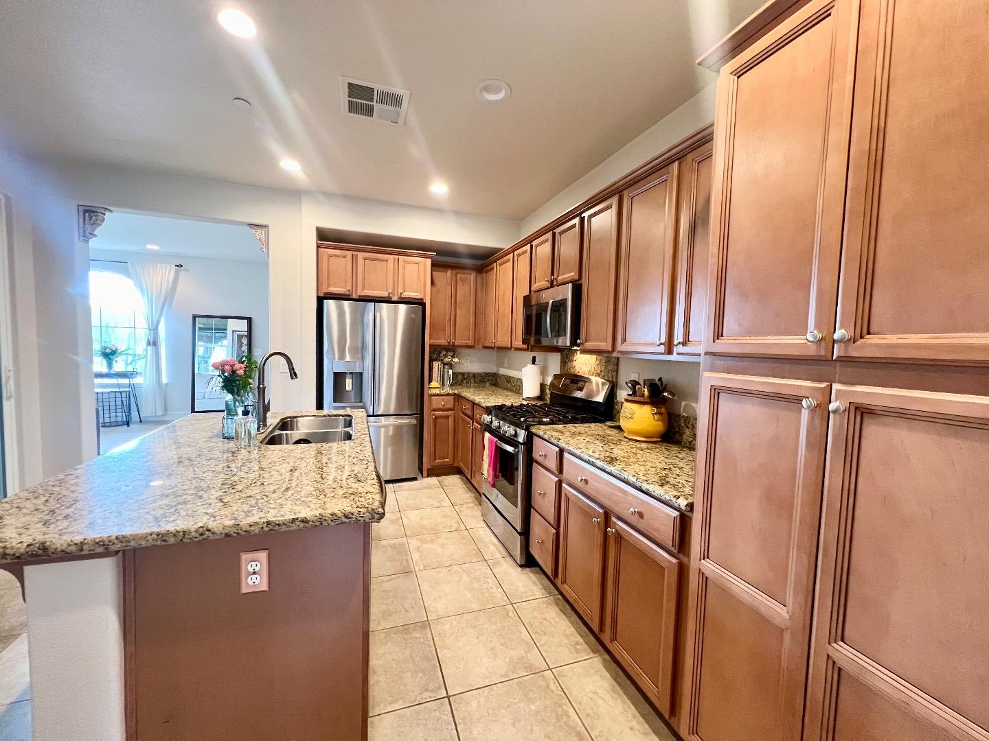 18643 McClellan Circle East Garrison, CA 93933 - Photo 31 of 42 a kitchen with stainless steel appliances granite countertop refrigerator a sink dishwasher a stove top oven and a dining table with wooden floor