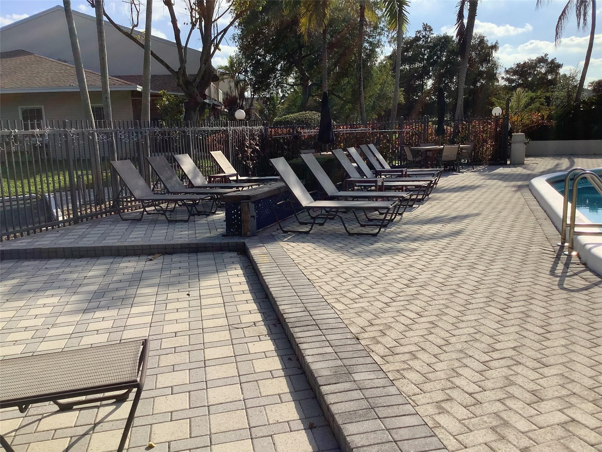 4765 South Hemingway Circle, Unit 68 Margate, FL 33063 - Photo 27 of 39 a view of a patio with table and chairs with wooden floor and fence
