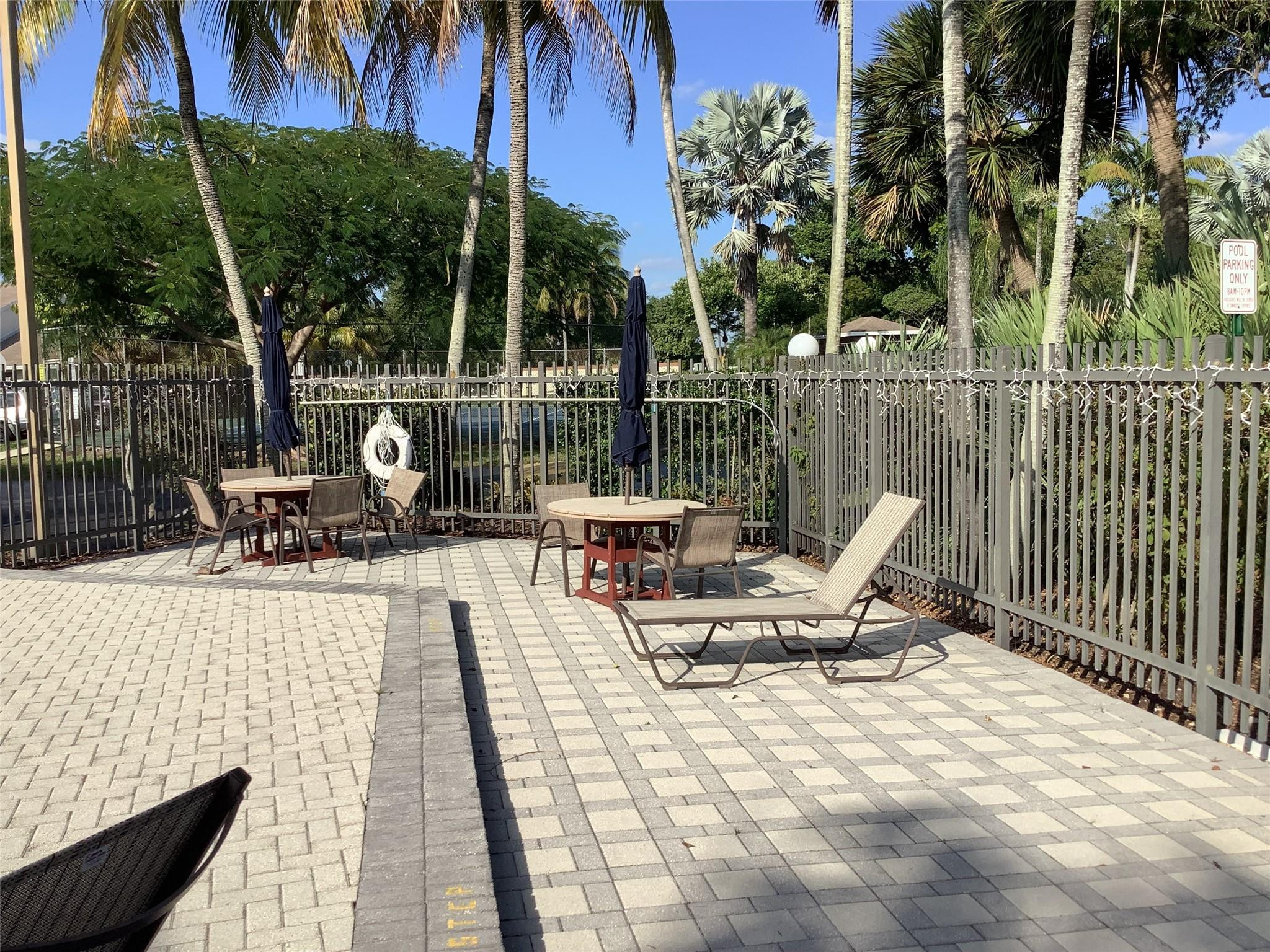 4765 South Hemingway Circle, Unit 68 Margate, FL 33063 - Photo 29 of 39 a view of a swimming pool with chairs and table in patio