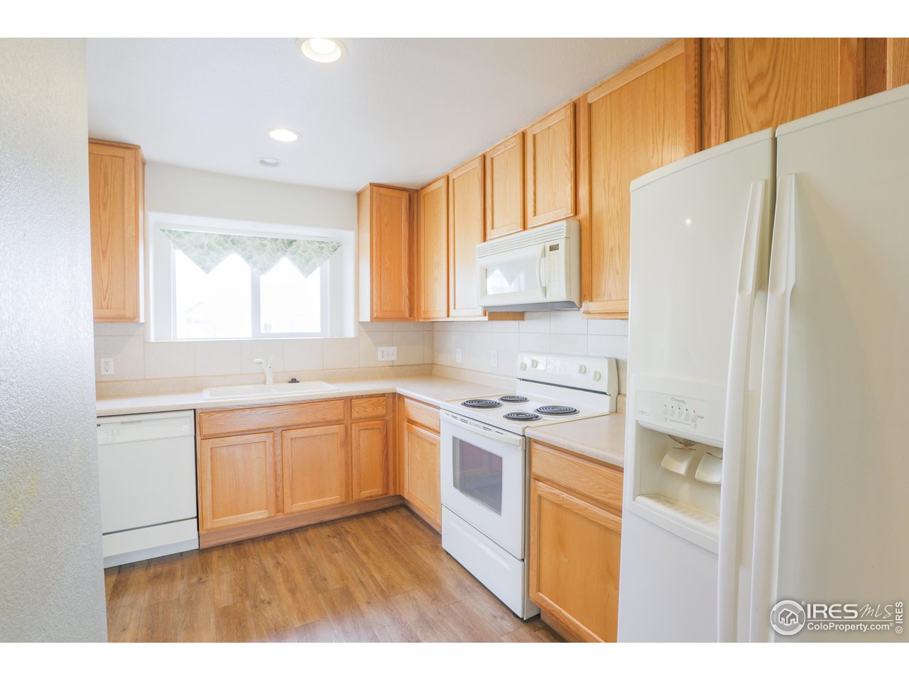 6827 Autumn Ridge Drive, Unit 4 Fort Collins, CO 80525 - Photo 11 of 28 a kitchen with a refrigerator a stove a sink and a window