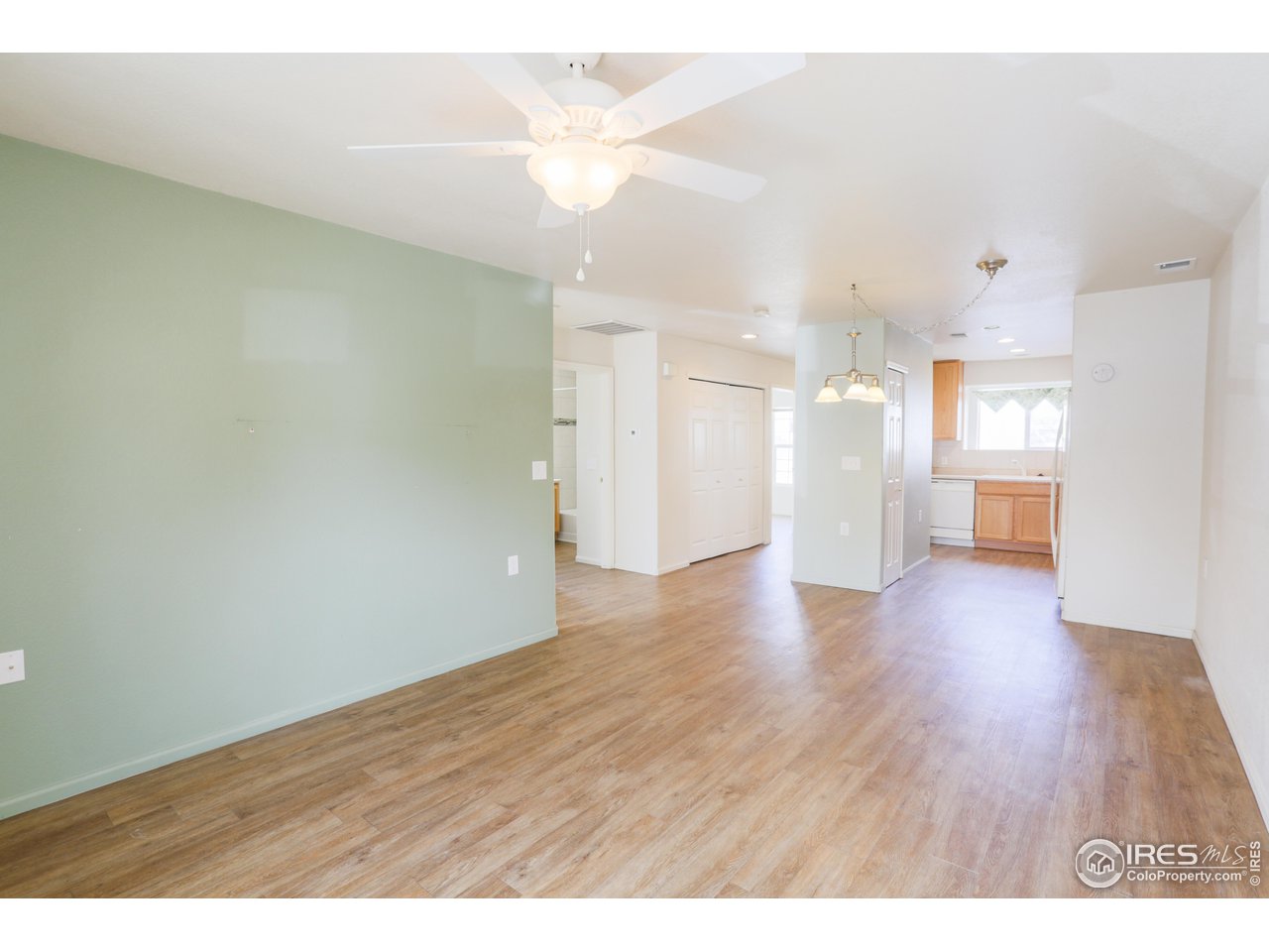 6827 Autumn Ridge Drive, Unit 4 Fort Collins, CO 80525 - Photo 6 of 28 a view of an empty room and a kitchen with wooden floor