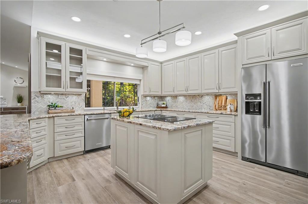 5186 Tallowood Way Naples, FL 34116 - Photo 12 of 50 a kitchen with white cabinets and white appliances