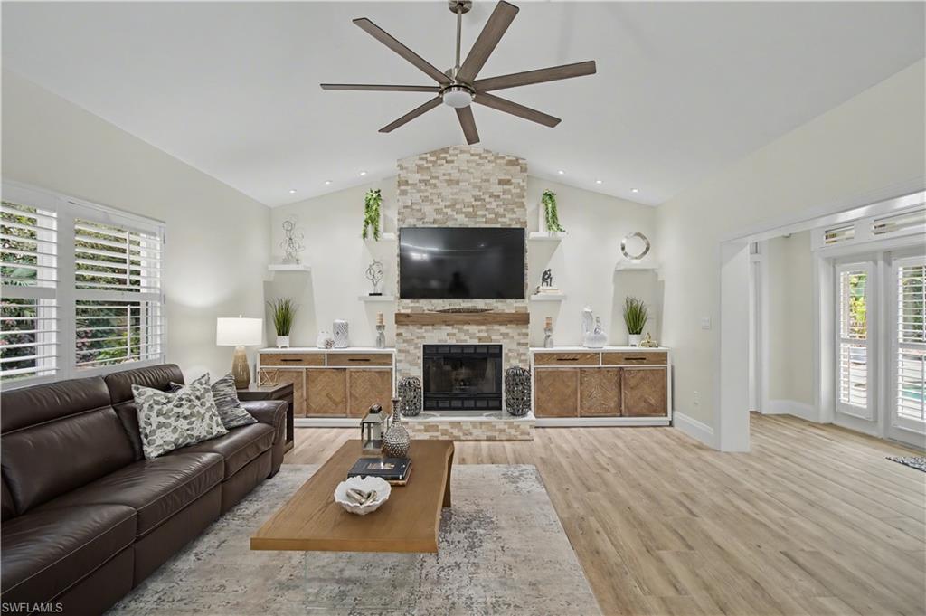 5186 Tallowood Way Naples, FL 34116 - Photo 15 of 50 a living room with furniture a fireplace and a flat screen tv