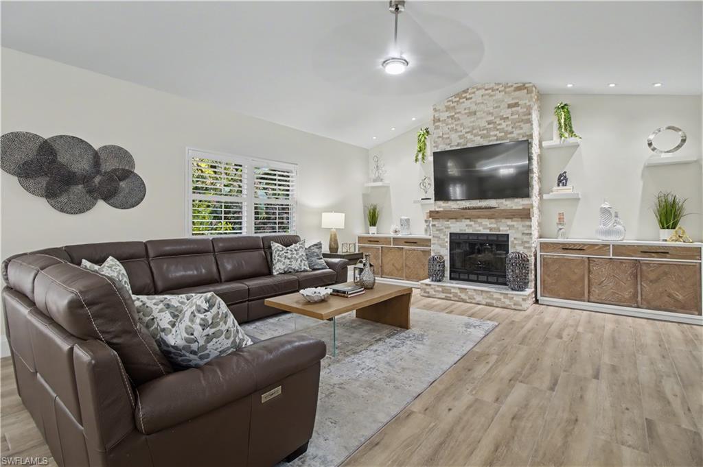 5186 Tallowood Way Naples, FL 34116 - Photo 16 of 50 a living room with furniture a fireplace and a flat screen tv