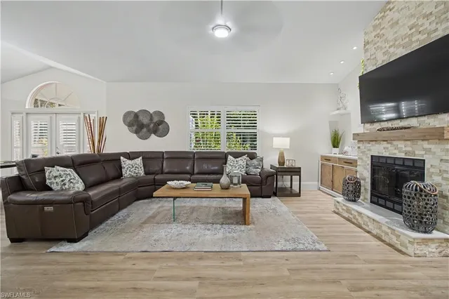 a living room with furniture a flat screen tv and a fireplace