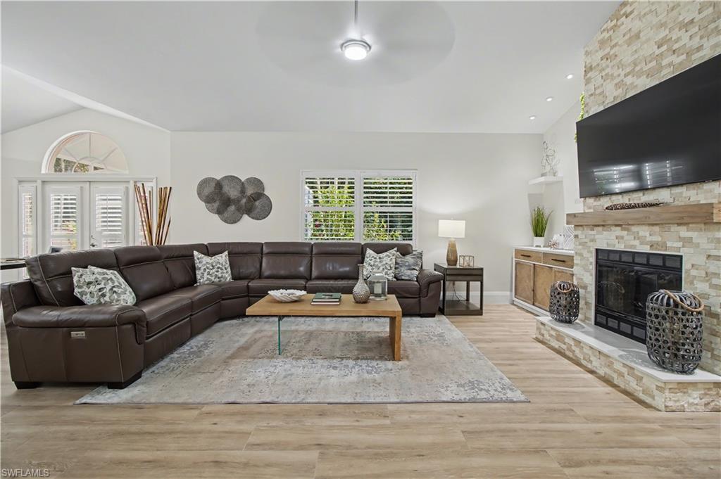 5186 Tallowood Way Naples, FL 34116 - Photo 17 of 50 a living room with furniture a flat screen tv and a fireplace