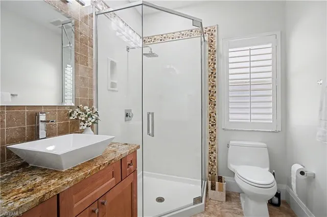 a bathroom with a granite countertop sink toilet and shower