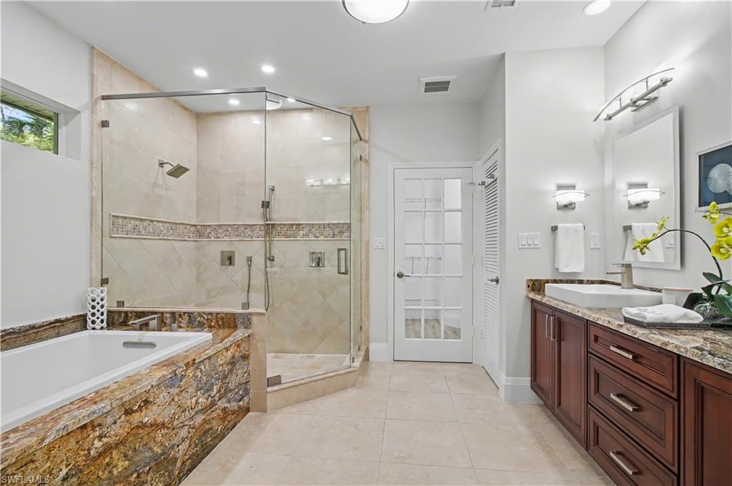 5186 Tallowood Way Naples, FL 34116 - Photo 24 of 50 a spacious bathroom with a granite countertop tub sink shower and mirror