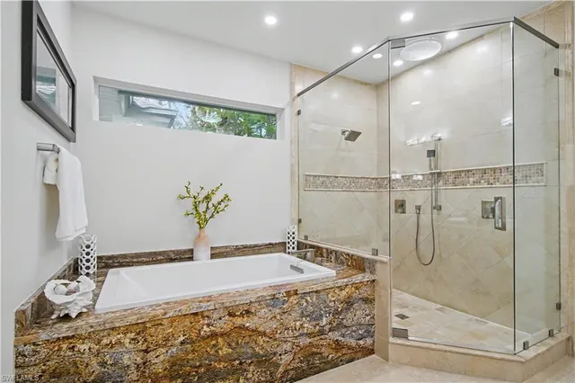 a spacious bathroom with a granite countertop sink a mirror and shower
