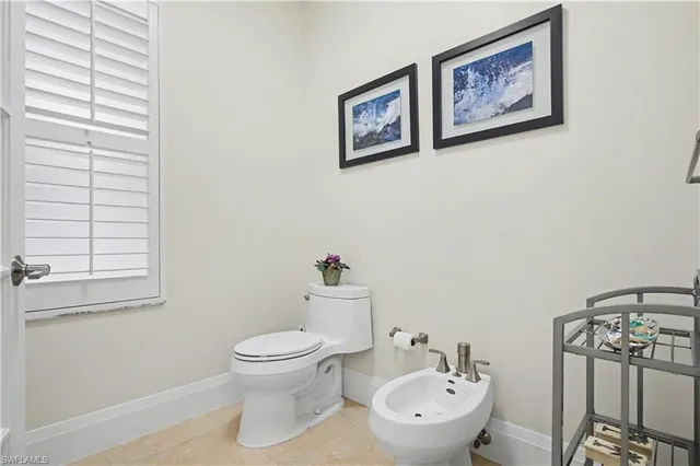 a bathroom with a toilet a sink and a window