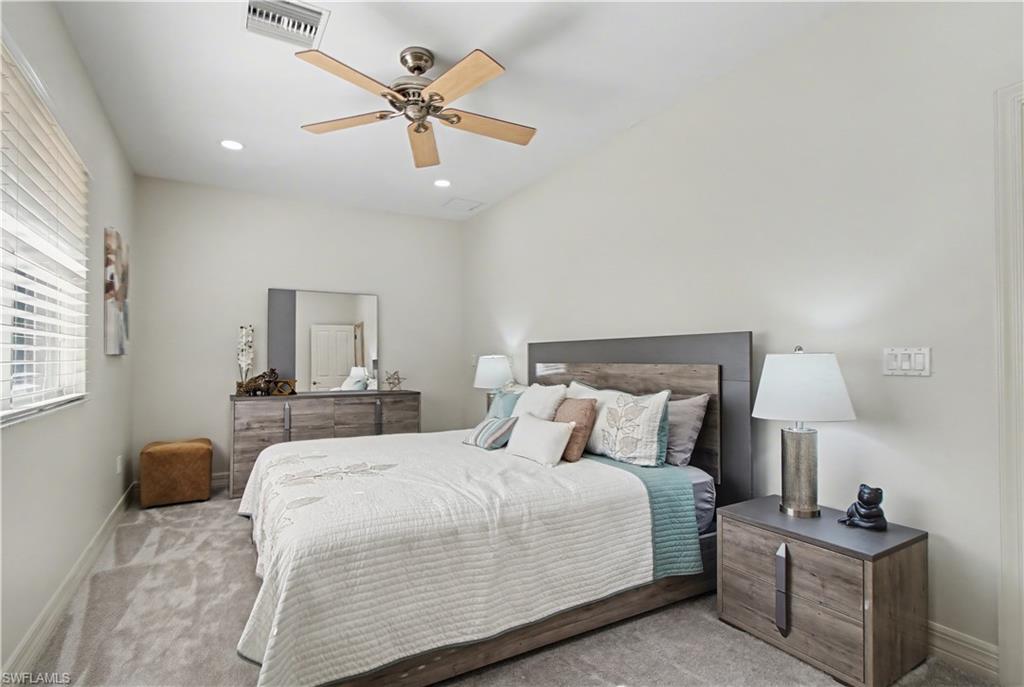 5186 Tallowood Way Naples, FL 34116 - Photo 36 of 50 a bedroom with a bed a chandelier and a table