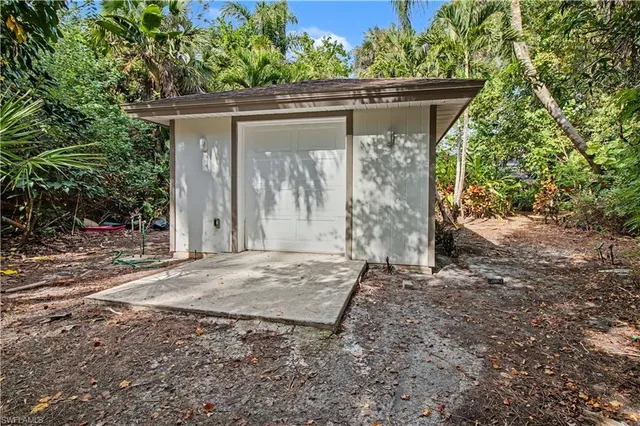a view of a small house with a tree in the background