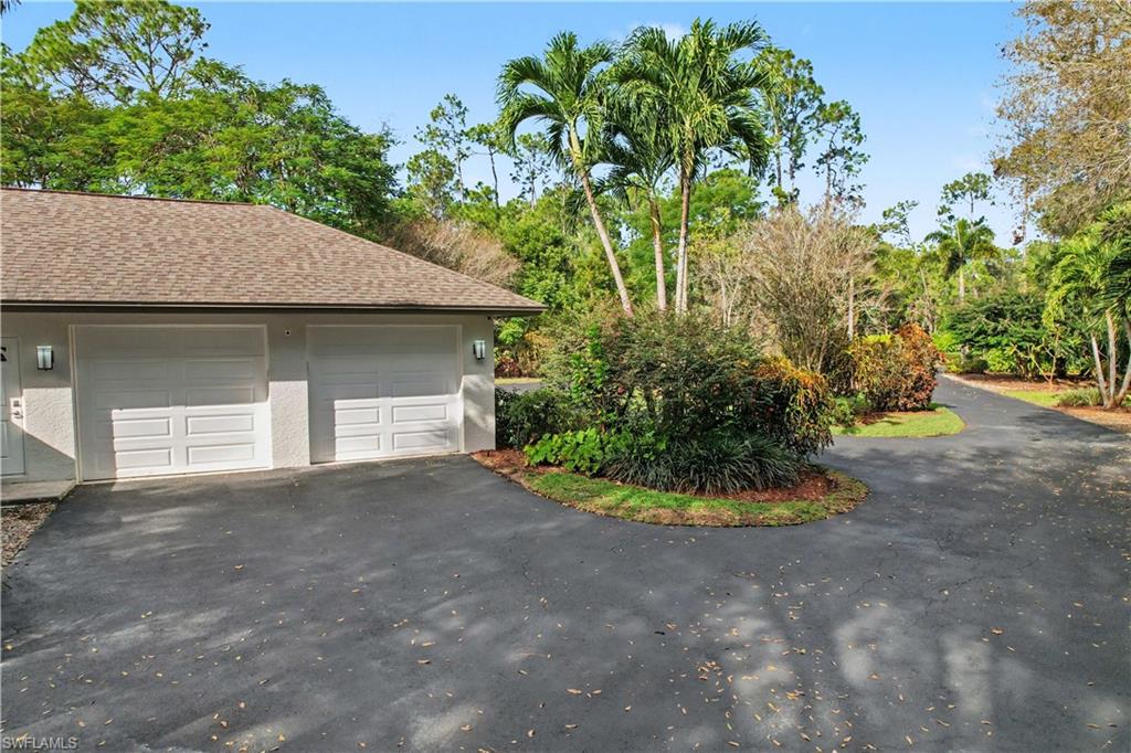 5186 Tallowood Way Naples, FL 34116 - Photo 49 of 50 a front view of a house with a yard and garage