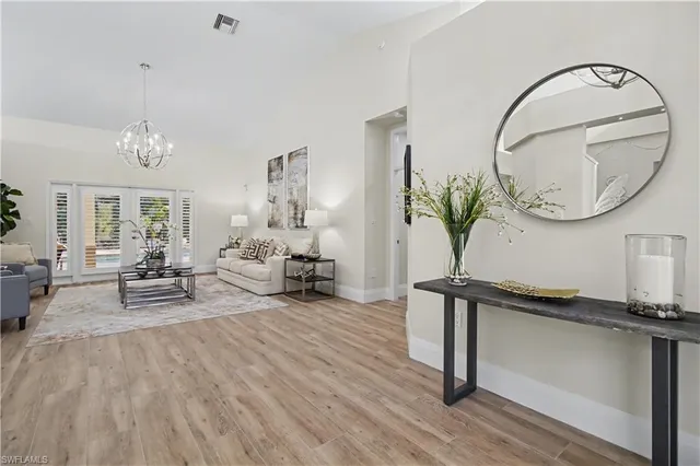 a living room with furniture a mirror and a potted plant
