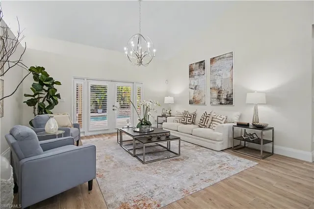 a living room with furniture chandelier and a table