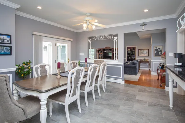 a view of a dining room and livingroom with furniture a rug a potted plant and a chandelier
