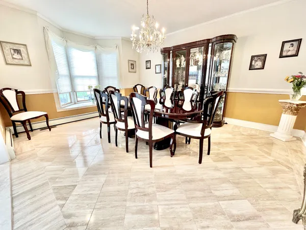 a dining room with furniture a chandelier and wooden floor