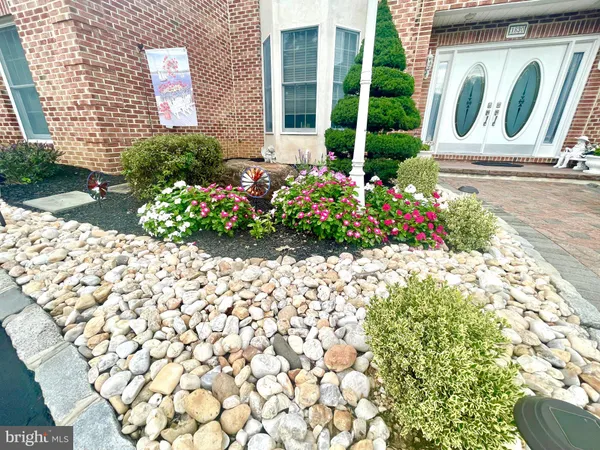 a front view of a house with a lot of flowers