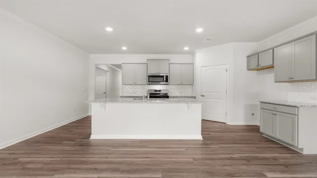 a kitchen with kitchen island granite countertop a sink stove and refrigerator