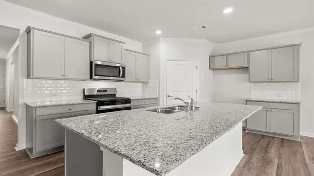 a kitchen with granite countertop a sink and cabinets