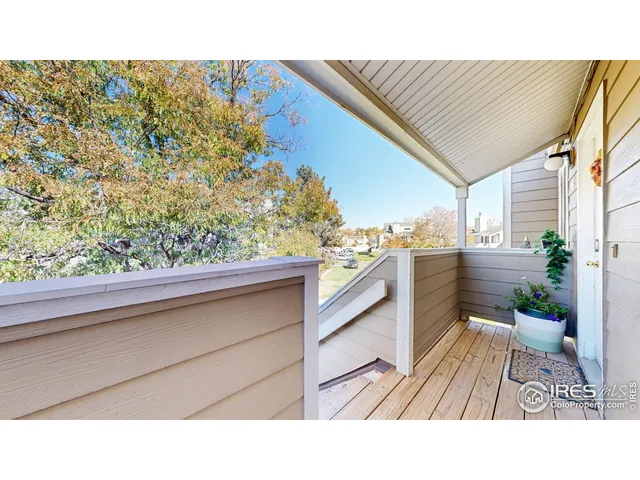a balcony with a potted plant and outdoor seating